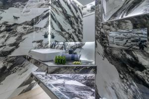 a bathroom with black and white marble walls and a sink at SithoniaRS Luxury 1st Floor Apartment With SeaView in Neos Marmaras