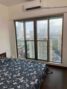 a bedroom with a bed and a large window at Room in Flat with Amazing City and Sea View in Mumbai