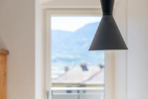a black lamp hanging in front of a window at Das Hubertus Suite Lena in Termeno