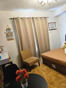 a bedroom with a bed and a desk and a chair at JETS'3 Condo Rentals in Bacolod