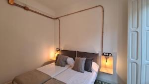 un dormitorio con una cama con dos almohadas en Casa Portela, en Cartagena 31 fotos más