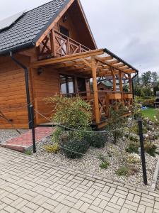 a large wooden cabin with a gambrel roof at Domek Zamajerz z widokiem na Jezioro in Niedzica Zamek