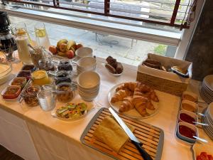 a table topped with different types of bread and pastries at Stryn House - Hotel & Apartments in Stryn