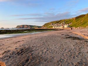 a sandy beach with footprints in the sand at Lobster Pot Cottage in Banff