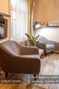 a living room with two couches in front of a window at Quiet Romantic Studio plus parking, Tartu Home in Tartu