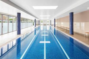 a large swimming pool with blue tile floors and windows at Meriton Suites Broadbeach in Gold Coast