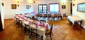 a dining room with tables and chairs with pink bows at Hotel Bílý Beránek Kralovice in Kralowitz
