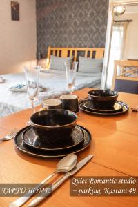 a table with two black bowls and glasses on it at Quiet Romantic Studio plus parking, Tartu Home in Tartu