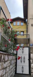 une porte menant à un bâtiment avec des roses rouges sur celui-ci dans l'établissement Apartments Stan, à Sarajevo