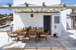 patio con tavolo e sedie sul tetto di El Verano Hideaway a Imerovigli