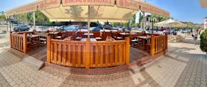 a restaurant with wooden tables and a large umbrella at Hotel Bílý Beránek Kralovice in Kralowitz