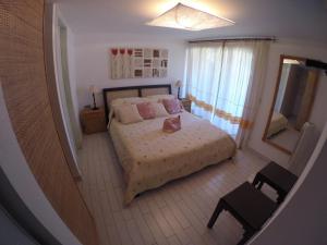 a small bedroom with a bed and a mirror at Luxury Apartment Sardegna in Marina di Portisco