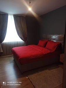 um quarto com uma cama vermelha e uma janela em DRY SUİTS em Istambul