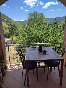 a wooden table and chairs on a balcony with a view at Villa Patty in Pian di Mulino