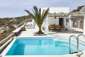 a villa with a swimming pool and a house at El Verano Hideaway in Imerovigli