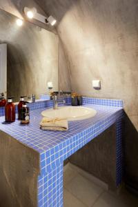 y baño con lavabo y encimera de azulejos azules. en El Verano Hideaway, en Imerovigli