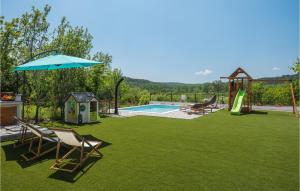 une cour avec une piscine et une aire de jeux avec des chaises et un parasol dans l'établissement Stunning Home In Roc With House A Panoramic View, à Roč