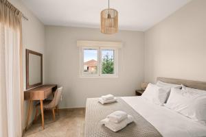 a bedroom with a bed and a desk and a window at Vasilopoulos Residences - Villa Chloe with private pool in Argostoli +13 photos