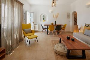 a living room with yellow chairs and a table at El Verano Hideaway in Imerovigli