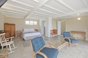 a bedroom with a bed and a table and chairs at Ganstever Suiderstrand Western Cape in Suiderstrand