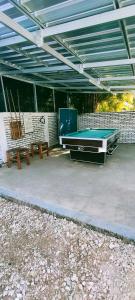 um pátio com uma mesa de bilhar e 2 bancos em Scar Reef Homestay em Jereweh