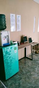 a counter with a refrigerator and a table with plates on it at Scar Reef Homestay in Jereweh