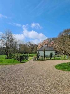 a gravel road in front of a white house at Magnolia Cottage - Kent in Lyminge