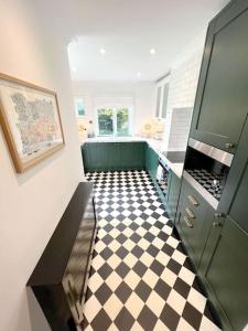 a kitchen with a black and white checkered floor at Magnolia Cottage - Kent in Lyminge