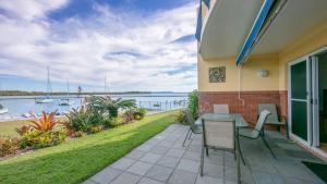 a patio with a table and chairs and a view of the water at Riverview Apartment 2 Block 2 in Iluka