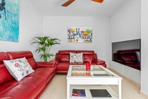 a living room with a red couch and a white coffee table at Luxury Flat in Skyscraper in Santa Cruz de Tenerife