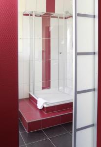 y baño con ducha de azulejos rojos y blancos. en Trierer Hof en Koblenz