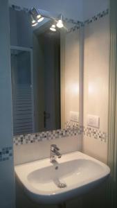 a bathroom sink with a mirror and a light at Agriturismo Villalta in Ponte Felcino