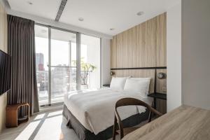 sypialnia z łóżkiem i dużym oknem w obiekcie 1LI7E Hotel w mieście Taizhong