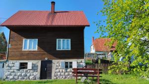 a house with a red roof and a bench at Central Rustic House in Žabljak