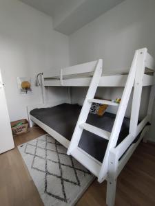 a white bunk bed with a ladder in a room at Toppilansalmi two bedroom apartment with a view in Oulu