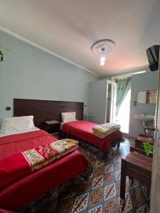アズルーにあるHotel des cedres,azrou marocのベッド2台とシンク付きのホテルルームです。