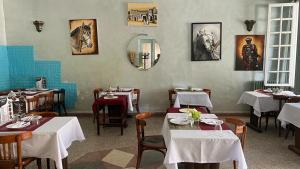 a dining room with tables and white tables and chairs at Hotel des cedres,azrou maroc in Azrou