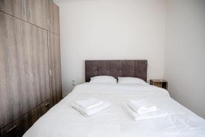 a bedroom with a large bed with two towels on it at John luxury apartment in Alexandroupoli