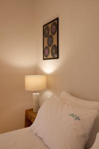 a bedroom with a bed with a lamp and a painting at MeYia studios in Thessaloniki