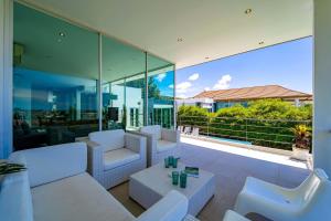 a living room with white furniture and large glass windows at Phu Montra Villa with Ocean View in Khao Tao