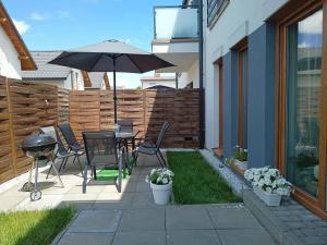 a patio with an umbrella and a table and chairs at Apartament przy Kopalni Srebra in Tarnowskie Góry