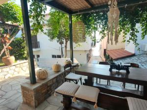 an outdoor patio with a wooden table and chairs at Galini Hotel Agios Ioannis Pelion in Agios Ioannis Pelio