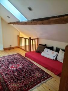 a bedroom with a bed and a rug in a attic at Pour les amoureux de ballades dans les Vosges - 4 nuits minimum in Bertrimoutier