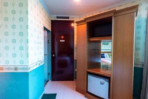 Urbanview Hotel P Residence Asemka في جاكرتا: مطبخ صغير مع باب أسود وتلفزيون