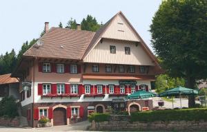 オーバーハルマースバッハにあるGasthaus Zur Lindeの赤い扉と屋根の大家