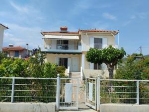 a white house with a fence in front of it at Calypso Two Bedroom Apartment in Kandia