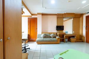 Urbanview Hotel P Residence Asemka في جاكرتا: غرفة معيشة مع أريكة ومكتب