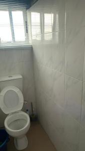 a bathroom with a white toilet and a window at Tommy’s place in Iki