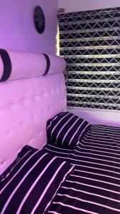 a black and white bed with a pillow on it at Tommy’s place in Iki
