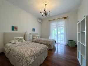 a bedroom with two beds and a chandelier at TheasHomly in Kastanéa